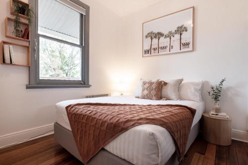 a bedroom with a large bed with a window at Walter Cottage As Cosy As It Is Convenient in Kings Park