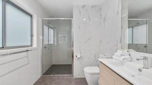 Un baño blanco con inodoro y ducha. en Pearls on Sapphire Beach, en Sapphire Beach