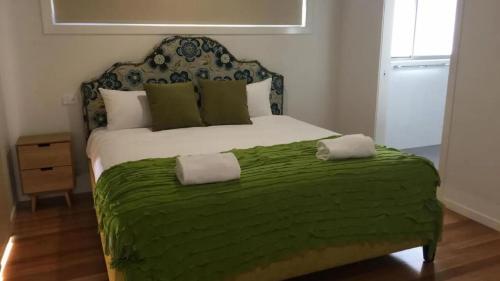 Un dormitorio con una cama grande con una manta verde. en Pearls on Sapphire Beach, en Sapphire Beach