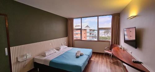 Cette petite chambre comprend un lit et une fenêtre. dans l'établissement Auberge du MOCAMBO, à Nouméa