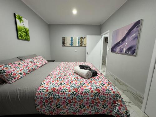 a bedroom with a bed with a colorful blanket on it at Home Away From Home in Auckland