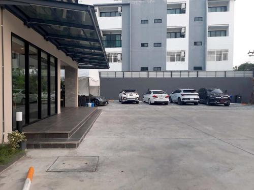 a parking lot with cars parked in front of a building at The 9 Residence Hotel in Bangkok