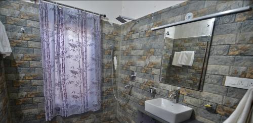 a bathroom with a purple shower curtain and a sink at Uttarakhand resort in Kausani