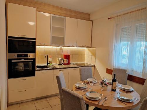 a kitchen with a wooden table with chairs around it at Apartments Slaven-50m from beach in Vinišće