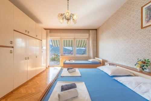 1 Schlafzimmer mit 2 Betten und einem Kronleuchter in der Unterkunft Apartments Kosta - 70m from sea in Vinišće