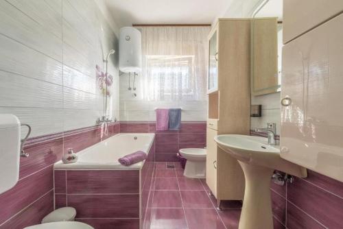 ein Badezimmer mit einer Badewanne, einem WC und einem Waschbecken in der Unterkunft Apartments Kosta - 70m from sea in Vinišće