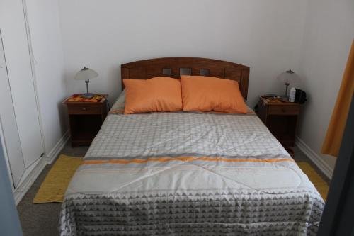 1 dormitorio con 2 almohadas de color naranja en Apartamento en Reñaca con Vista al Mar, en Viña del Mar