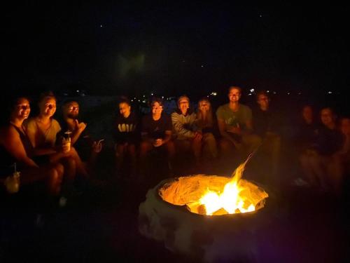 a group of people sitting around a fire at Open Gate Hostel Hawaii in Pahoa