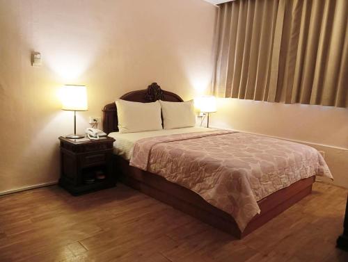 Habitación de hotel con 1 cama y 2 lámparas en Ideal Hot Spring Water Hotel en Jiaoxi