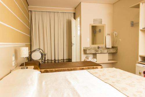 a hotel room with a bed and a mirror at Pousada Cataratas in Foz do Iguaçu