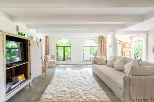 a living room with a white couch and a tv at Studio Birdsong in East Ballina