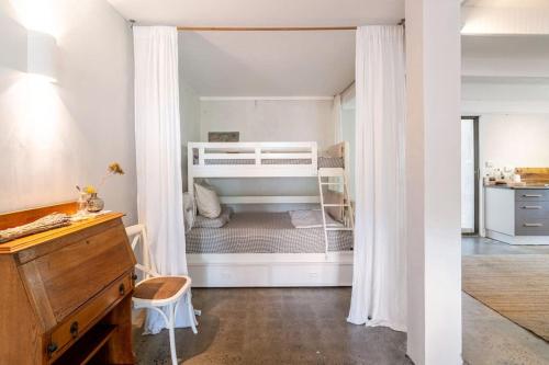 sypialnia z 2 łóżkami piętrowymi i biurkiem w obiekcie Studio Birdsong w mieście East Ballina