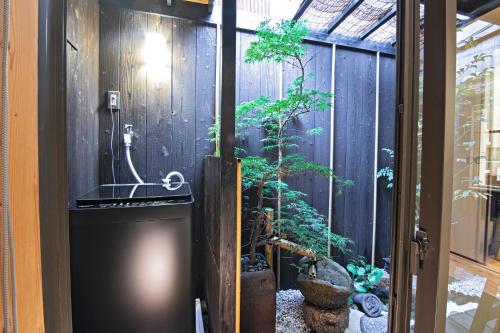 a door leading into a garden with a plant at -時の宿 上七軒- Kyoto Machiya 金閣寺周辺 in Kyoto