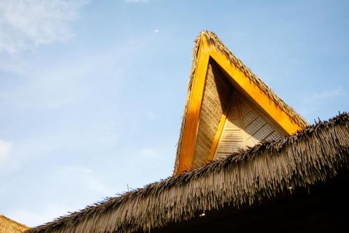 a window on top of a thatch roof at Bahay Artisano in El Nido