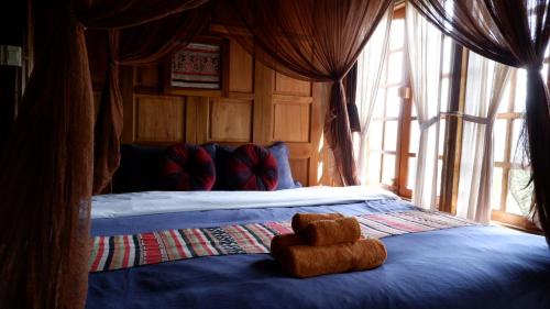 a teddy bear sitting on a bed in a bedroom at Lua Pu Luong in Pu Luong