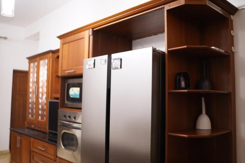 a kitchen with a refrigerator and a microwave at Sandy Bliss Villa in Sri Jayewardenepura Kotte