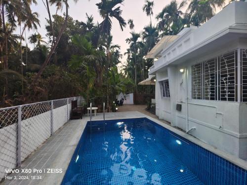 una piscina di fronte a una casa di Coconut casa villa revdanda a Revadanda