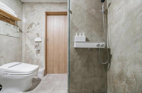 ein Bad mit einem WC und einer Dusche in der Unterkunft S Hotel in Jeju-do