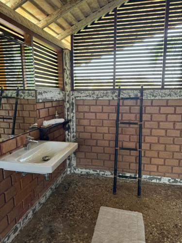 a bathroom with a sink and a brick wall at OHEI in Tangalle
