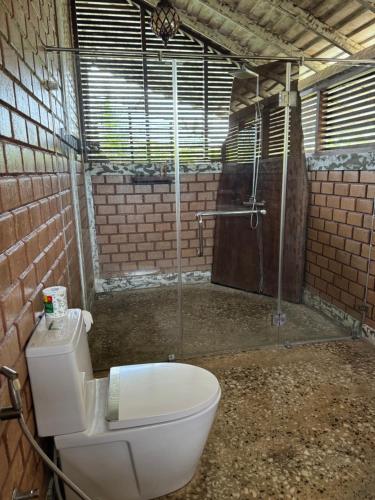 a bathroom with a toilet and a shower at OHEI in Tangalle