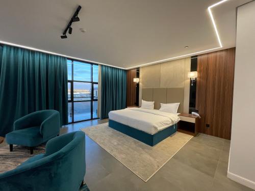 Habitación de hotel con 1 cama y 2 sillas en شاليهات راف, en Khamis Mushayt