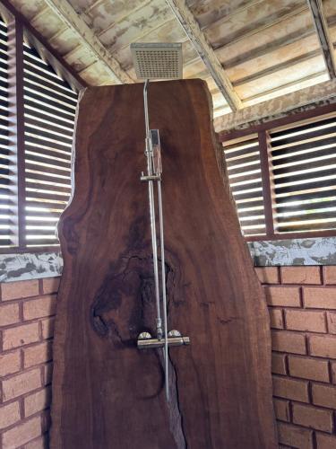 uma grande estrutura de madeira com um chuveiro num quarto em OHEI em Tangalle