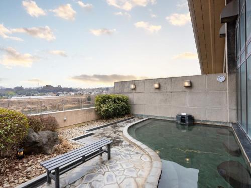a lap pool in a building with a bench next to it at Tabist Healthy Pal Akagi in Shibukawa