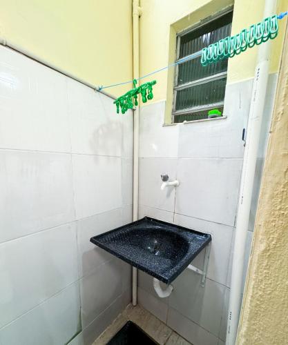 a bathroom with a black sink and a window at Apartamento confortável mobiliado 03 in Manaus