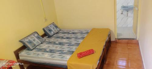 Un dormitorio con una cama con un zapato rojo. en Laxmi Guest House (Arambol Beach) en Arambol