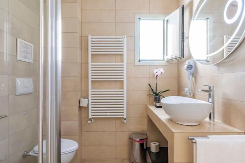 a bathroom with a sink and a toilet and a mirror at Villa Soleanna Residence in Vieste