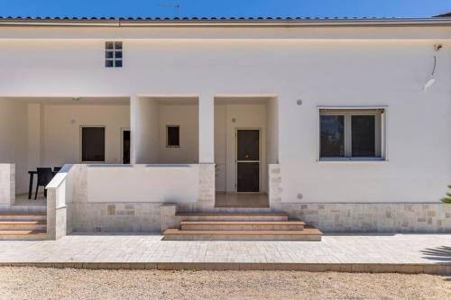 a white house with stairs in front of it at Villa Soleanna Residence in Vieste