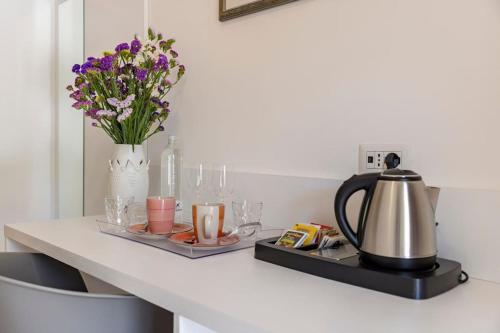 a counter with a tea kettle and flowers on it at Villa Soleanna Residence in Vieste
