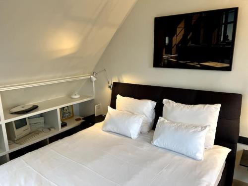 1 dormitorio con 1 cama con sábanas y almohadas blancas en Agelandkaai (.be) Free Parking en Ghent