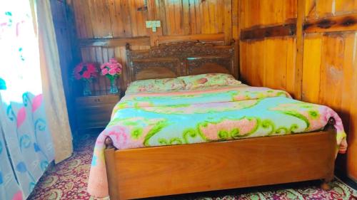 a bedroom with a bed with a wooden head board at Houseboat young wild Rose in Srinagar