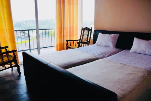 1 dormitorio con 2 camas y balcón en Channa villa, en Nuwara Eliya