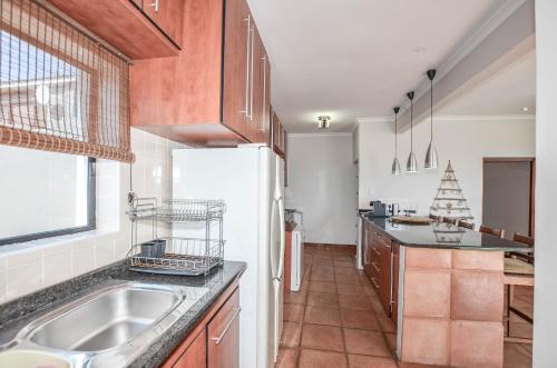 a kitchen with a sink and a white refrigerator at NetReg in Yzerfontein