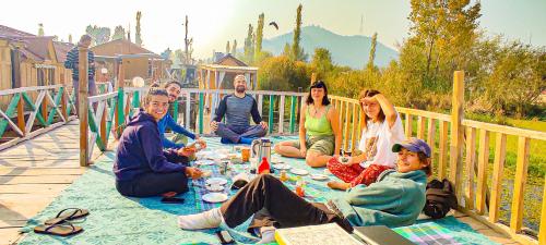 a group of people sitting around a picnic table at Houseboat young wild Rose in Srinagar