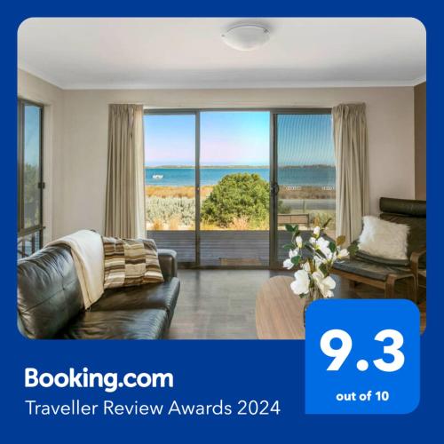 a living room with a view of the ocean at Absolute Waterfront Views and Kayaks in Meningie