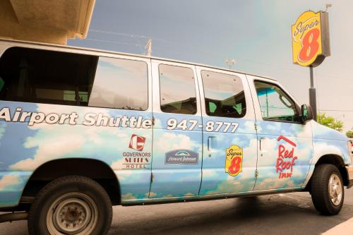 a blue and white van parked next to a building at Super 8 by Wyndham Oklahoma Airport Fairgrounds West in Oklahoma City