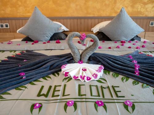two beds with swans on them with a hello life sign at Ahola Thoddoo, Maldives in Thoddoo