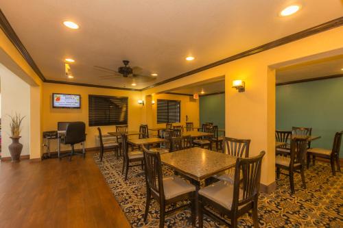 a dining room with tables and chairs and a tv at Super 8 by Wyndham Oklahoma Airport Fairgrounds West in Oklahoma City
