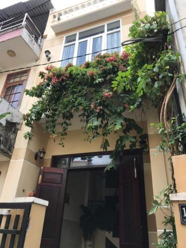 een gebouw met een balkon met bloemen erop bij Lazánia Homestay Hội An in Hội An