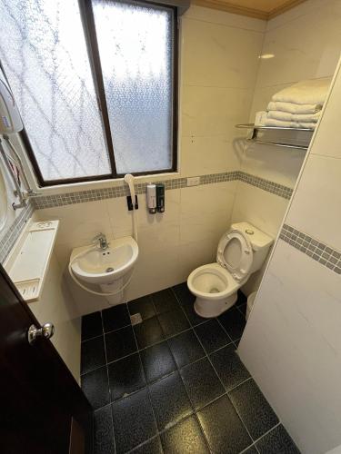 a bathroom with a sink and a toilet and a window at 逢甲Inn好窩 in Taichung