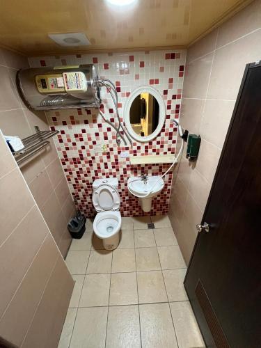 a small bathroom with a toilet and a sink at 逢甲Inn好窩 in Taichung