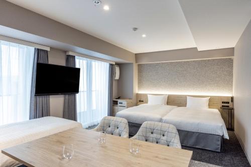 a hotel room with two beds and a flat screen tv at Tokyu Stay Shibuya in Tokyo