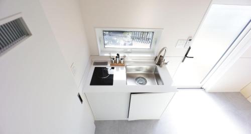 eine kleine Küche mit einem Waschbecken und einem Fenster in der Unterkunft Starium Jecheon in Jecheon