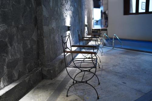 a row of chairs against a stone wall at Sandy Bliss Villa in Sri Jayewardenepura Kotte