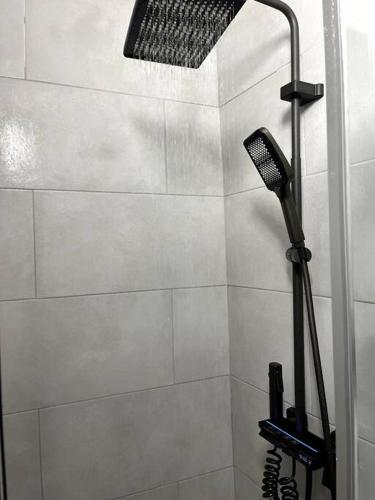 een douche met een douchekop in de badkamer bij 5min from Paris / Cosy Appartment in Levallois-Perret