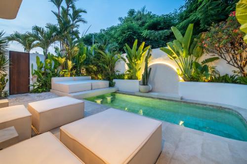 an outdoor patio with a swimming pool and a villa at Casa Dala Canggu in Canggu