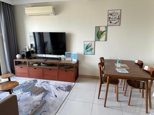 MrK Penthouse at Timurbay في كُوانتان: غرفة معيشة مع طاولة طعام وتلفزيون